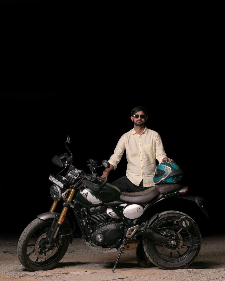 Yash Yadav standing with his Triumph Scrambler 400X motorcycle